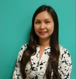 Asian woman with long brown hair against a teal background