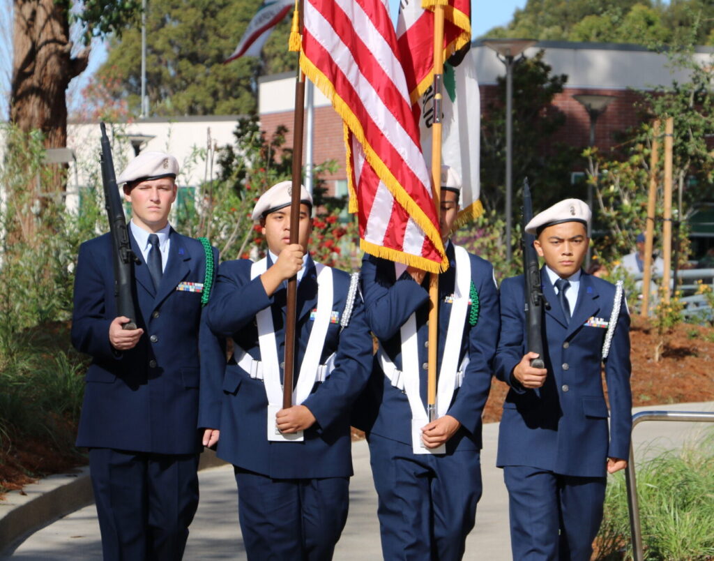 four individuals escorting a US flag